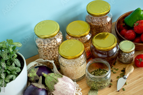 Zero waste healthy food-cereals, seeds, vegetables flat lay on grey background. Groceries in textile bags,glass jars, wooden bowl. Eco friendly plastic free low waste lifestyle.