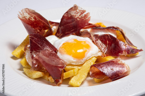 Typical Spain food named huevos rotos. photo