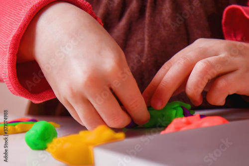 Process of modeling of plasticine: close up child's hands sculpt figures. Horizontal image.