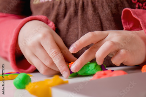 Process of modeling of plasticine: close up child's hands sculpt figures