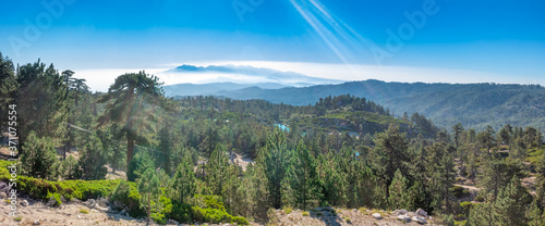 Wide panoramic of the San Bernardino mountains from the top of a local ski resort during the summer  near Running Springs  California with lens flare 
