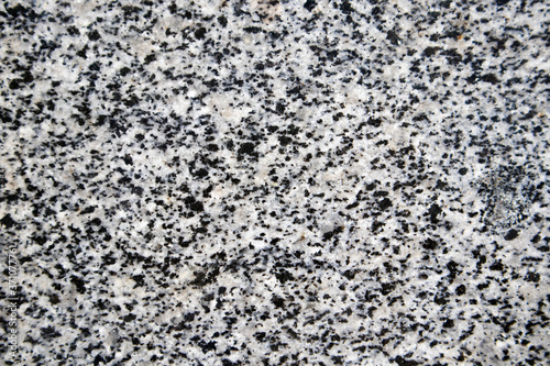 Unpolished surface of granite slab with black and grey texture.