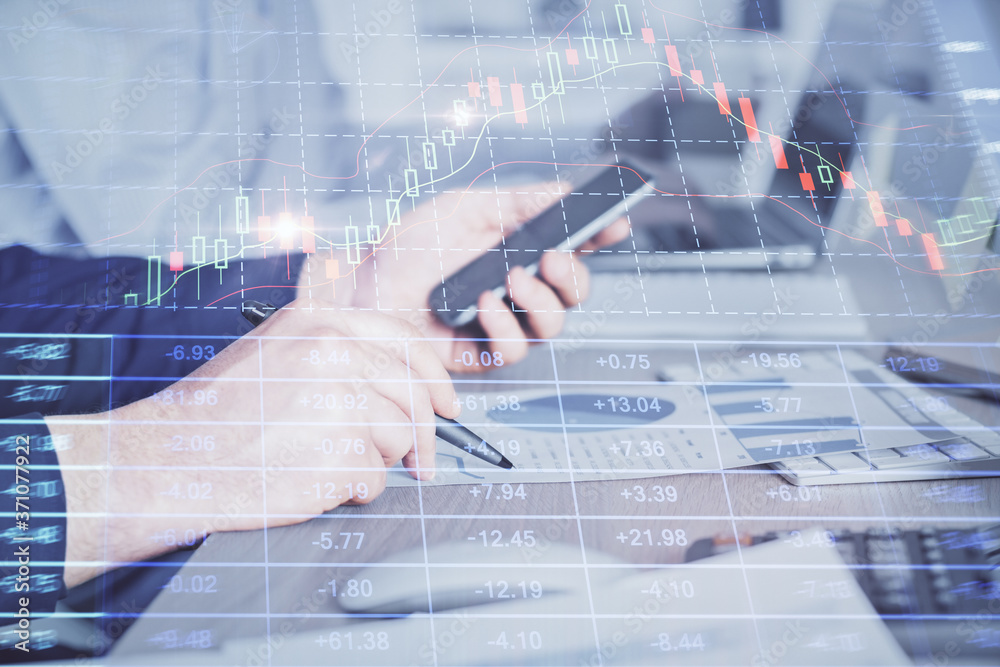 Double exposure of man's hands holding and using a digital device and forex graph drawing. Financial market concept. Double exposure of man's hands holding and using a digital device and forex graph drawing. Financial market concept.