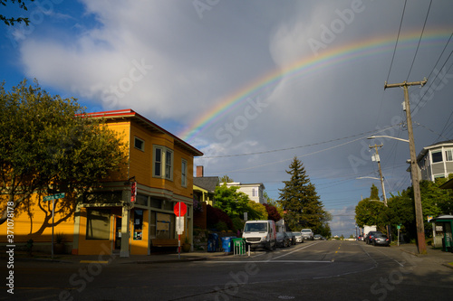 Rainbow Over Buildings and Street with Blue Sky in The City photo