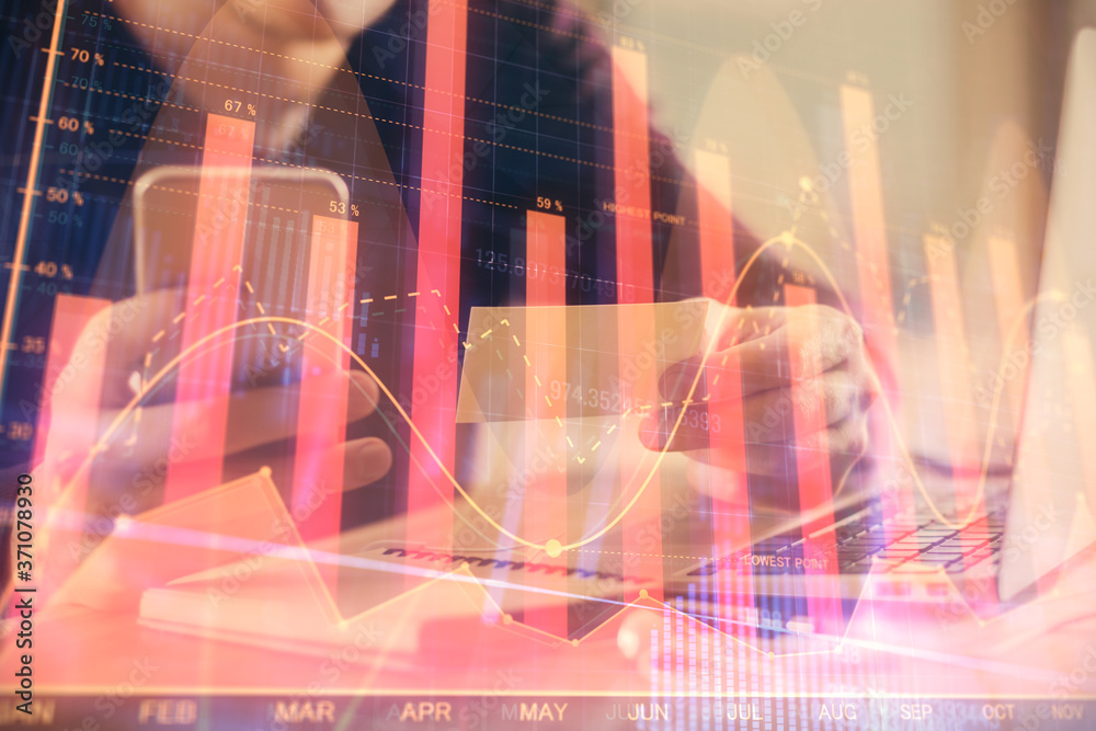 Double exposure of man's hands holding and using a phone and financial graph drawing. Analysis concept.