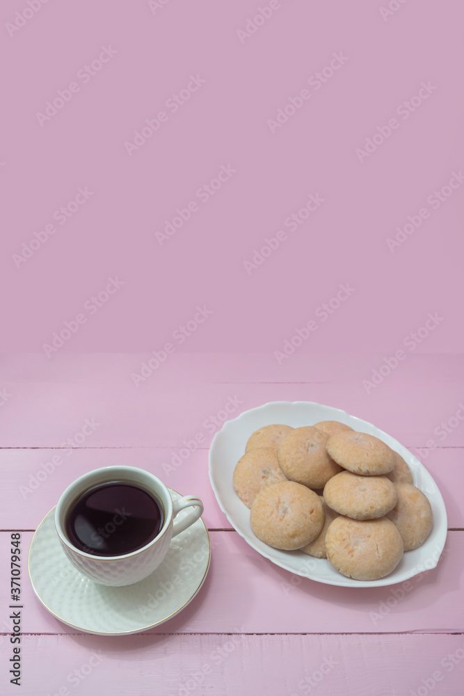 Cup of Americano coffee and homemade cookies on pink background. Copy space. The concept of romance, tenderness, coffee time Cup of Americano coffee and homemade cookies on pink background. Copy space. The concept of romance, tenderness, coffee time