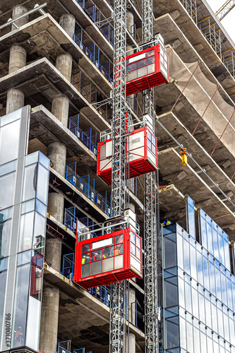 Elevators lift workers to the construction sites of a skyscraper under construction