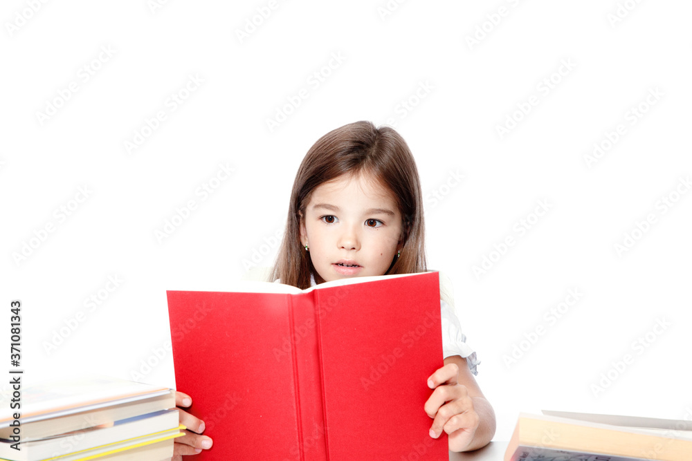 Young cute girl sitting at the table and reading a book Young cute girl sitting at the table and reading a book
