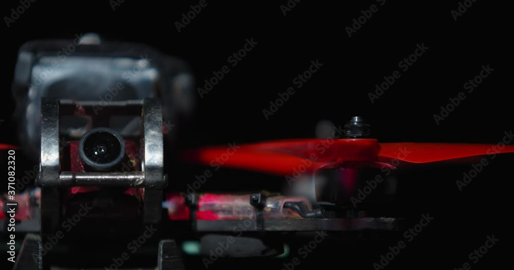 FPV drone from up close with the spinning red blades, studio footage FPV drone from up close with the spinning red blades, studio footage