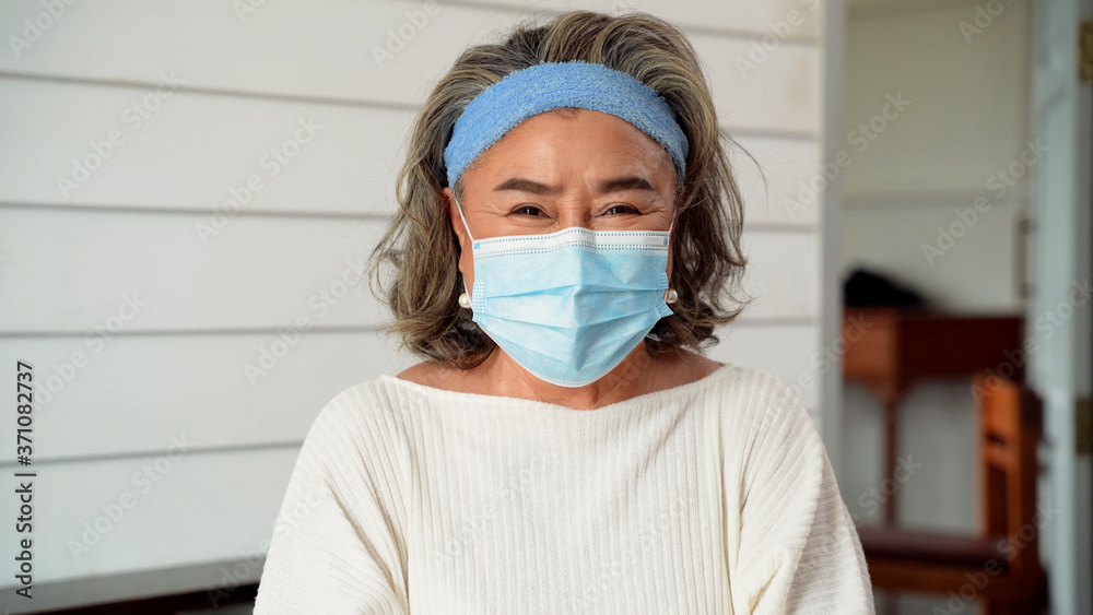 An elderly Asian woman is wearing a mask to prevent infection from the Covid 19 virus. An elderly Asian woman is wearing a mask to prevent infection from the Covid 19 virus.
