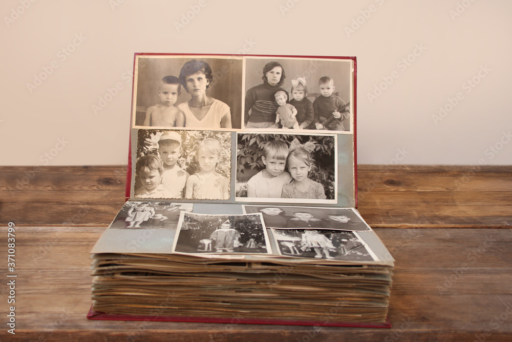 old retro album with vintage monochrome photographs in sepia color, the concept of genealogy, the memory of ancestors, family ties, childhood memories - obrazy, fototapety, plakaty 