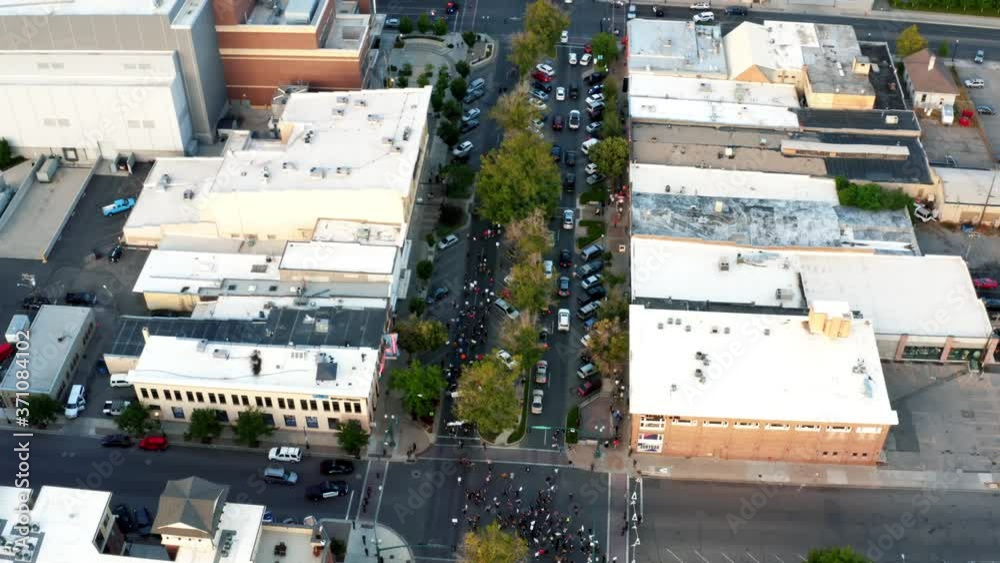 Provo, Utah / USA - July 1st 2020: Aerial flyover drone shot of Pro Trump protestors walking in the middle of center street after a shooting at a Black Lives Matter Protest the day before. Provo, Utah / USA - July 1st 2020: Aerial flyover drone shot of Pro Trump protestors walking in the middle of center street after a shooting at a Black Lives Matter Protest the day before.