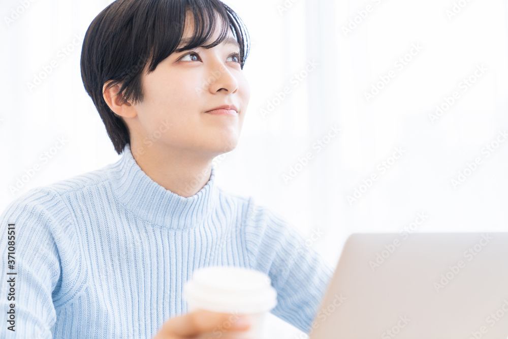 部屋でラップトップコンピューターを見る女性 部屋でラップトップコンピューターを見る女性