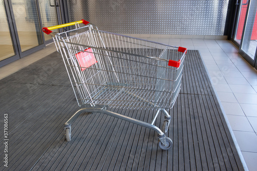 Foto Empty shopping cart at the entrance to the supermarket