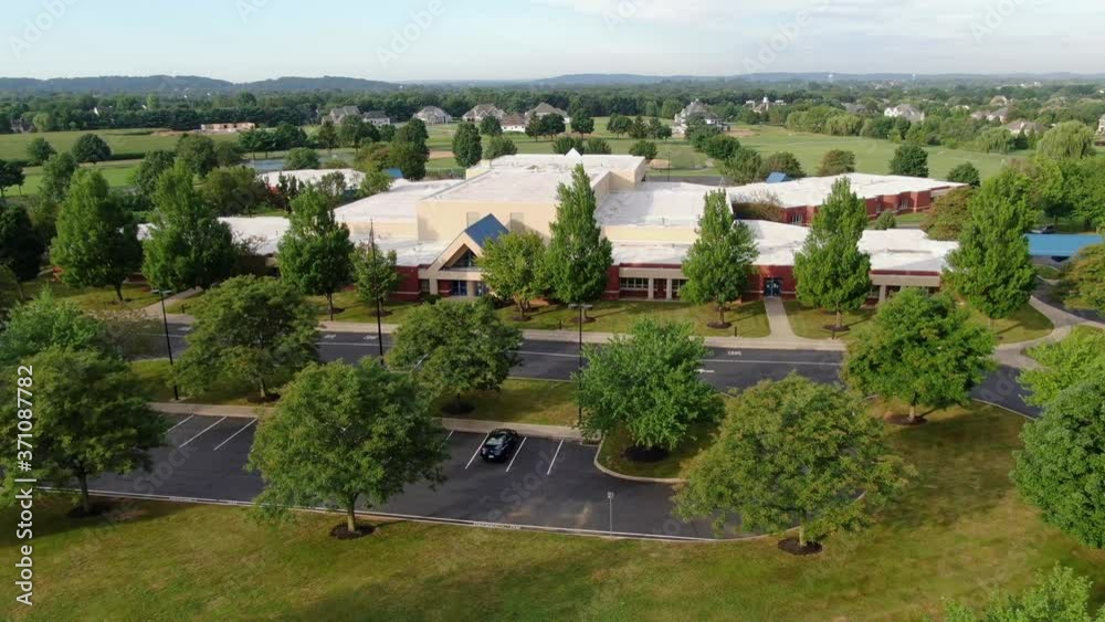 Aerial flight, wide dolly shot, then past American flag at new school building in Pennsylvania, USA Aerial flight, wide dolly shot, then past American flag at new school building in Pennsylvania, USA