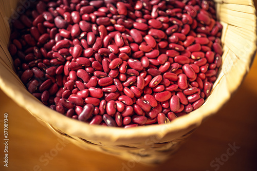 Exotic colorful mexican beans on wicker basket. Top view of legumes. Concept of beans food. Exotic beans on wooden table. Rustic background of beans. Colorful legumes on rustic setting.