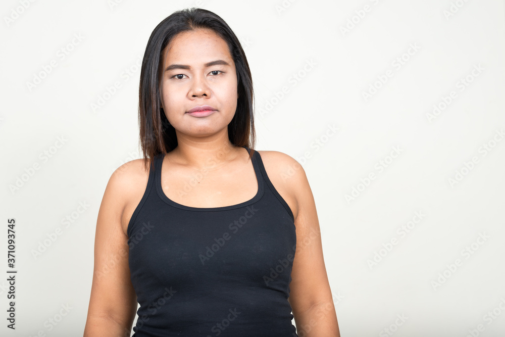 Portrait of young overweight Asian woman against white background Portrait of young overweight Asian woman against white background