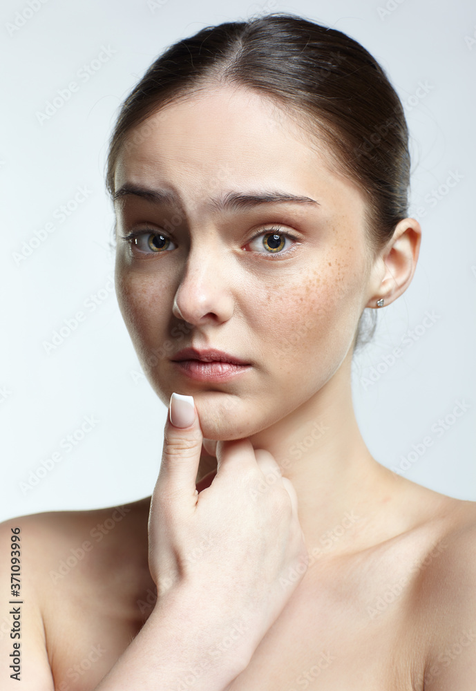 Headshot of emotional female face portrait with unhappy misunderstanding facial expression.