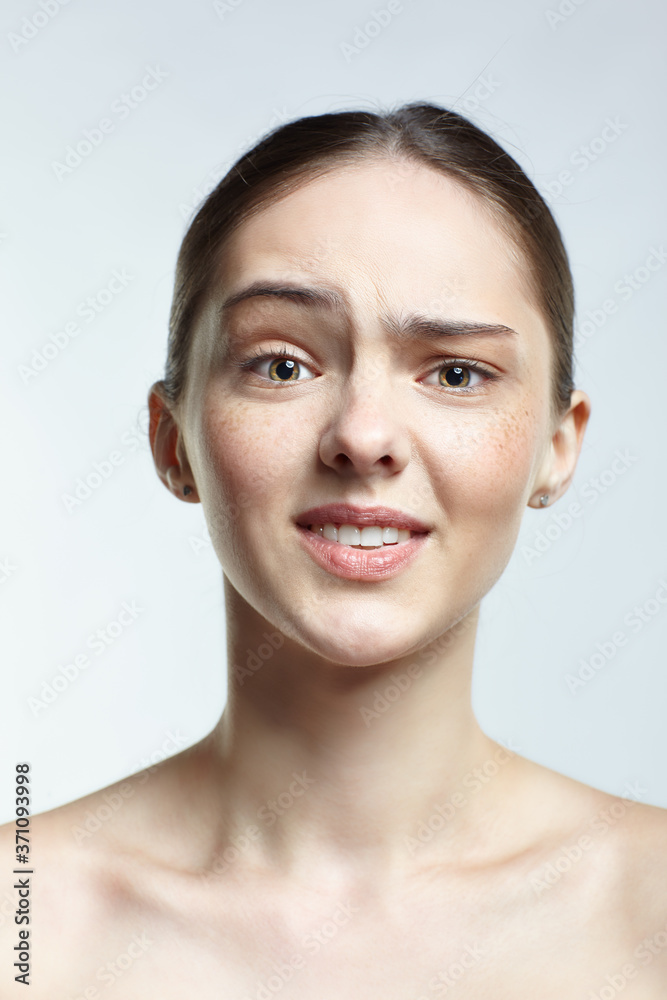 Headshot of emotional female face portrait with displeased facial expression. Headshot of emotional female face portrait with displeased facial expression.