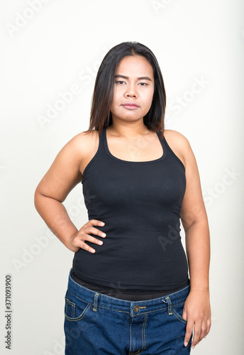 Portrait of young overweight Asian woman against white background