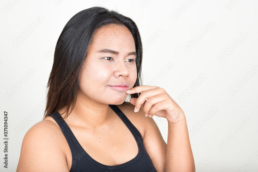 Portrait of young overweight Asian woman against white background
