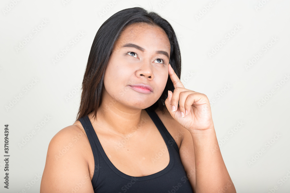 Portrait of young overweight Asian woman against white background Portrait of young overweight Asian woman against white background