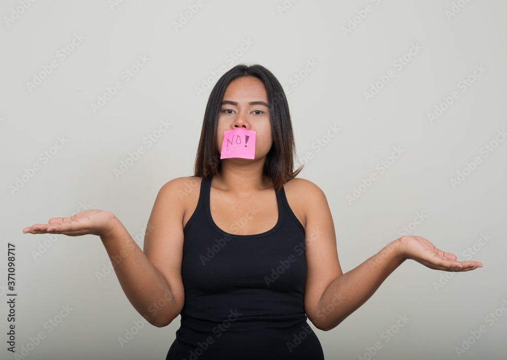 Portrait of young overweight Asian woman against white background Portrait of young overweight Asian woman against white background