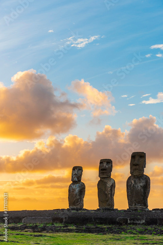 Moai statues at sunrise in vertical format with copy space, Ahu Tongariki, Easter Island (Rapa Nui), Chile. photo