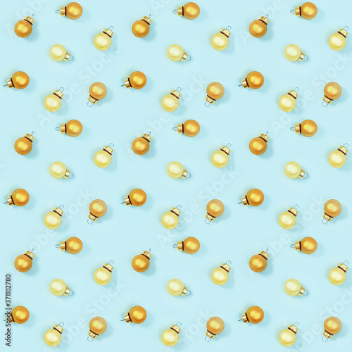 Seamless regular creative pattern with gloden shiny small Christmas balls on blue paper.