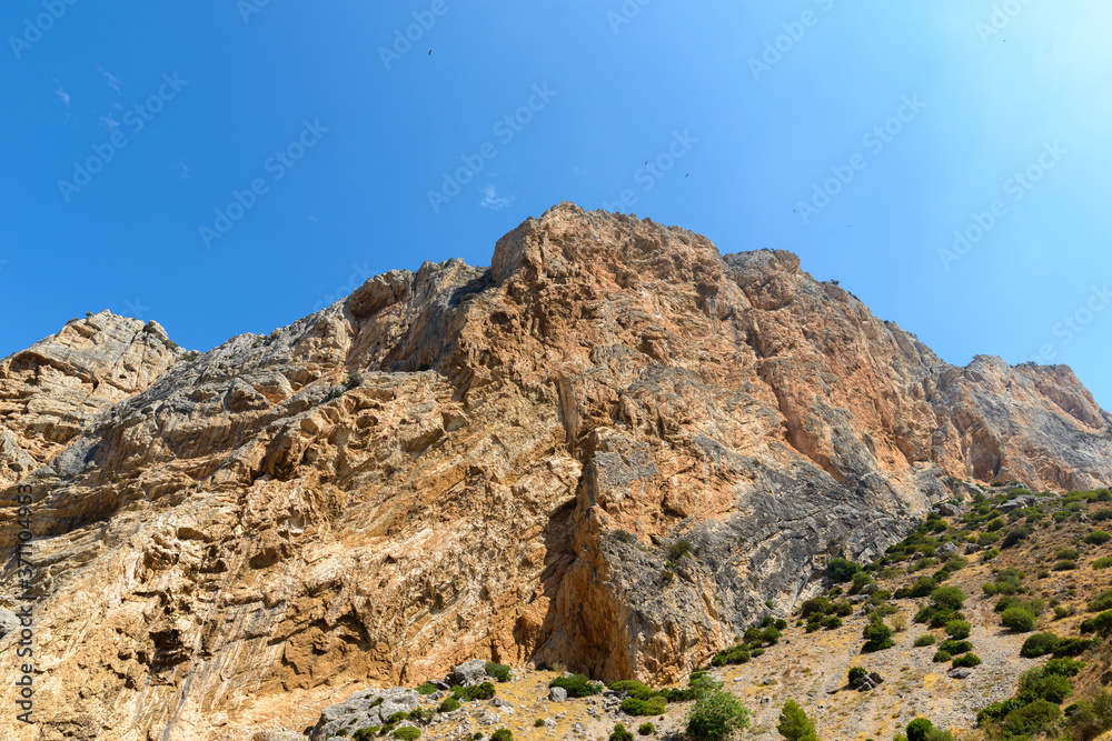 View of rocky mountain cliff and blue sky View of rocky mountain cliff and blue sky