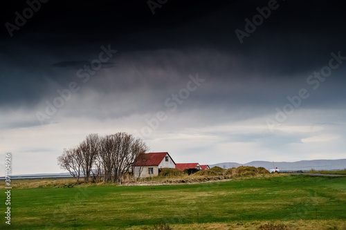 Foto Icelandic Cottage house under the ominous dark clouds