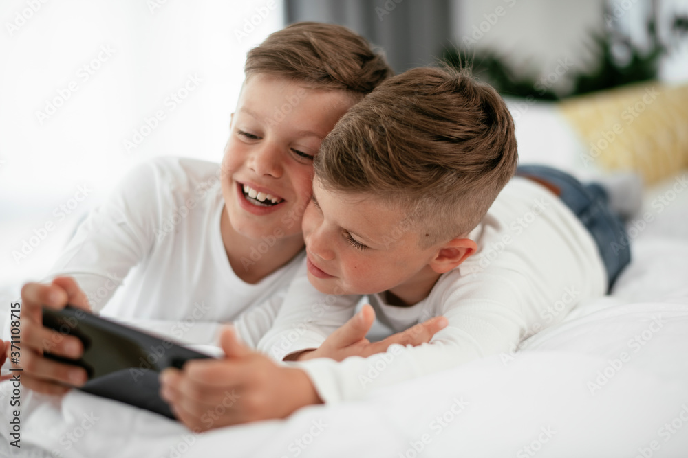 Two little brothers are playing games on the phone. Beautiful boys enjoying at home... Two little brothers are playing games on the phone. Beautiful boys enjoying at home...