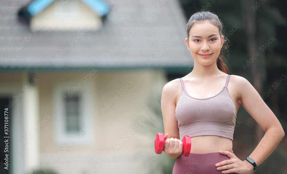 Portrait of young beautiful sportswoman holding red dumbbell. Portrait of young beautiful sportswoman holding red dumbbell.