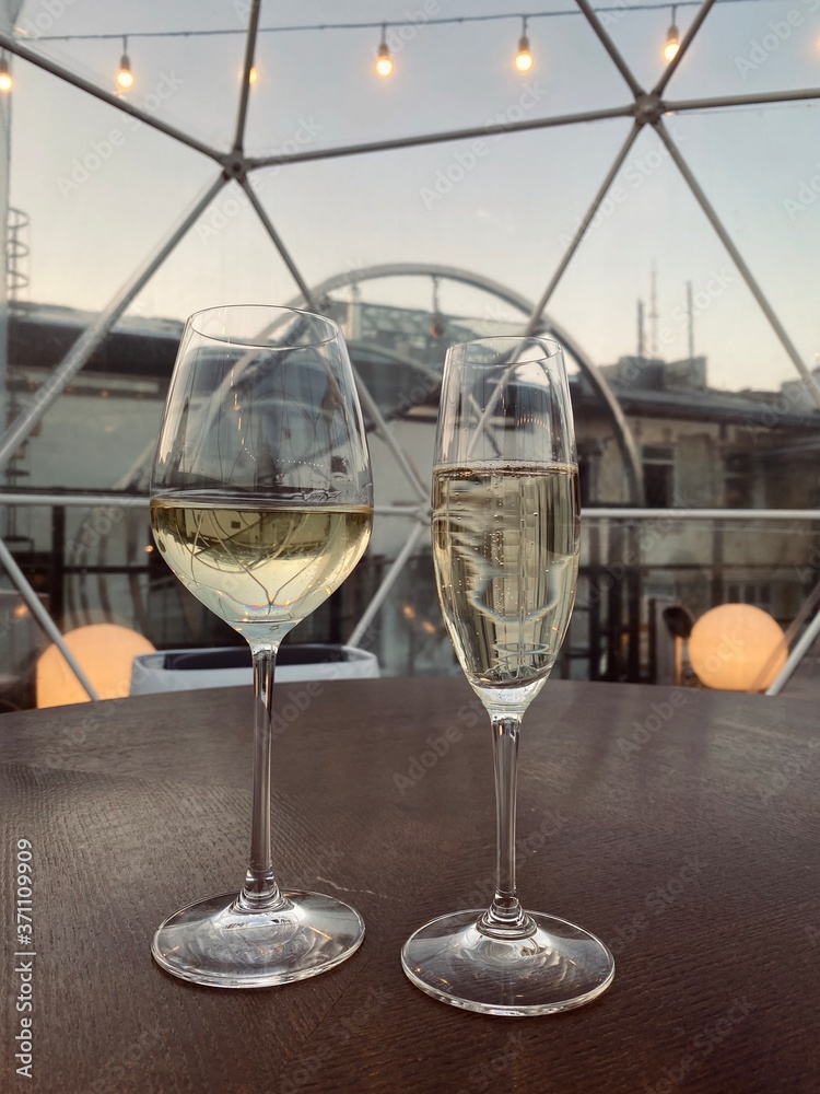 Obraz premium The two glasses on the table with drink. Sunset view