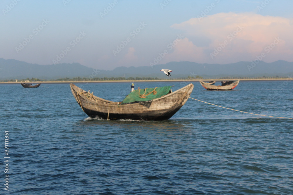 Fishing boats in Bay of Bengal Bangladesh Burma Border with a Seagal flying Fishing boats in Bay of Bengal Bangladesh Burma Border with a Seagal flying