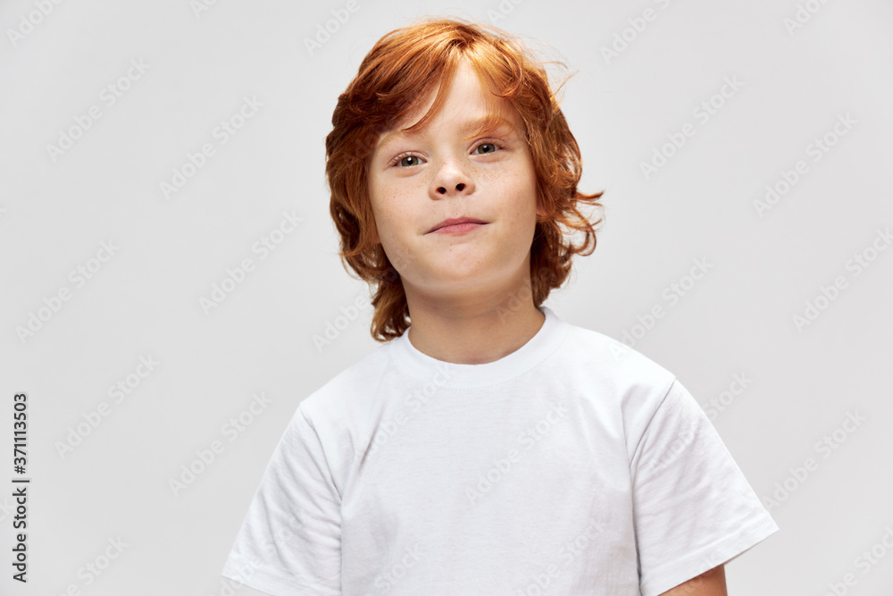 Red-haired boy with freckles on his face close-up white t-shirt cropped 