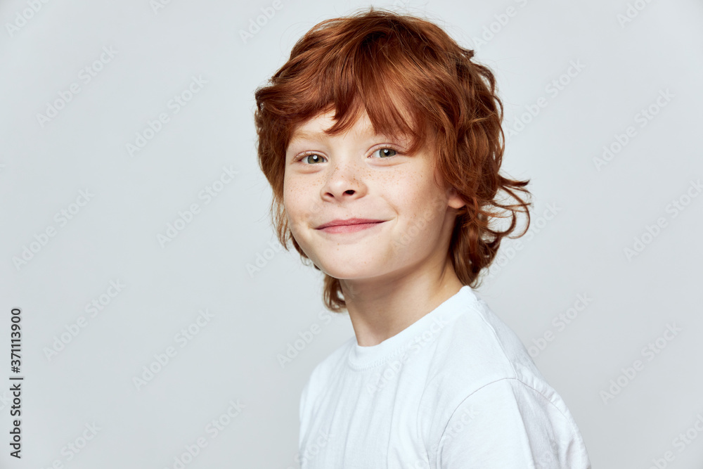 Red-haired boy with freckles on his face close-up white t-shirt Red-haired boy with freckles on his face close-up white t-shirt