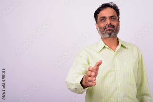 Portrait of mature handsome bearded Indian businessman