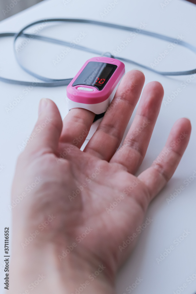 Hand with a portable pulse oximeter on the finger Hand with a portable pulse oximeter on the finger