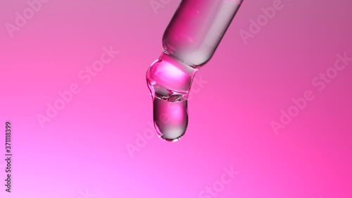 Water dropper in slow motion on pink background