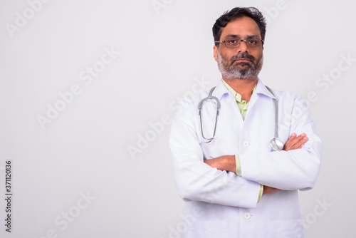 Portrait of mature handsome bearded Indian man doctor