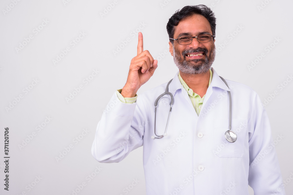 Portrait of happy mature handsome bearded Indian man doctor Portrait of happy mature handsome bearded Indian man doctor