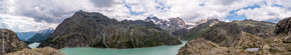 Panorama Alpen, Bernina von der Italienischen Südseite mit Campomoro den Stauseen Lago Campomoro und Lago Alpe Gera im Sommer bei leicht  bewölktem Himmel