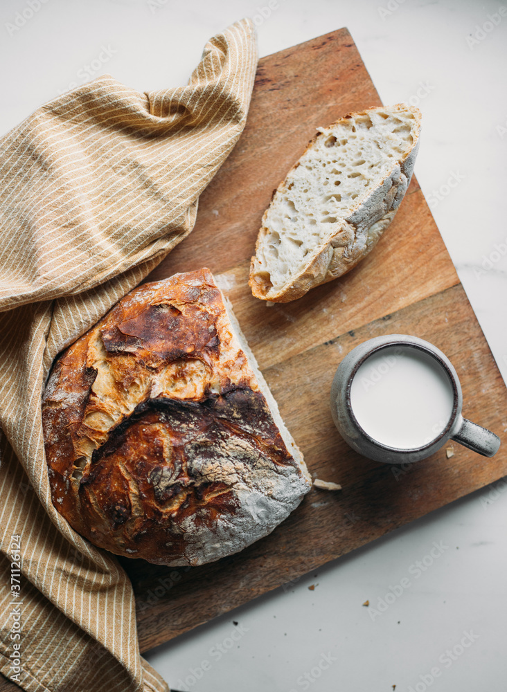 fresh artisan bread on wood tray over marble table with copy space fresh artisan bread on wood tray over marble table with copy space