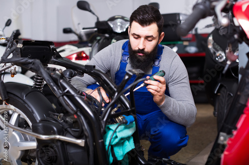 Operating master captures the details on a motorbike in his workshop