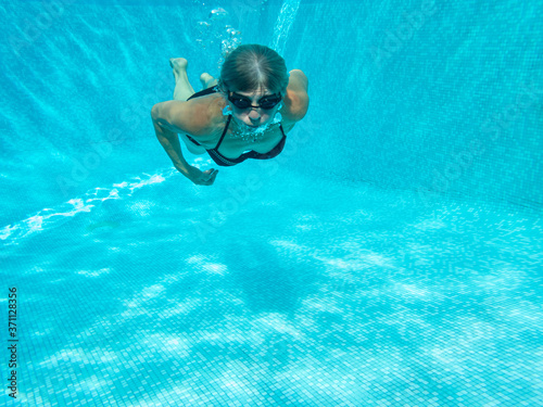 A person who swims in a blue pool
