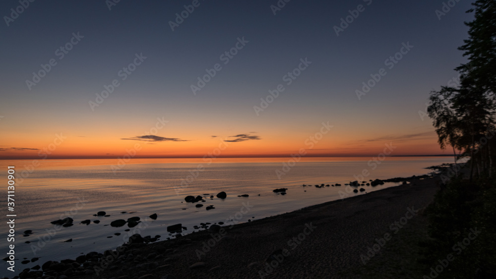 orange sunset by the sea, dark stone silhouettes in the foreground, summer orange sunset by the sea, dark stone silhouettes in the foreground, summer