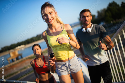 Fitness, sport, people and running concept. Happy fit friends running outdoors