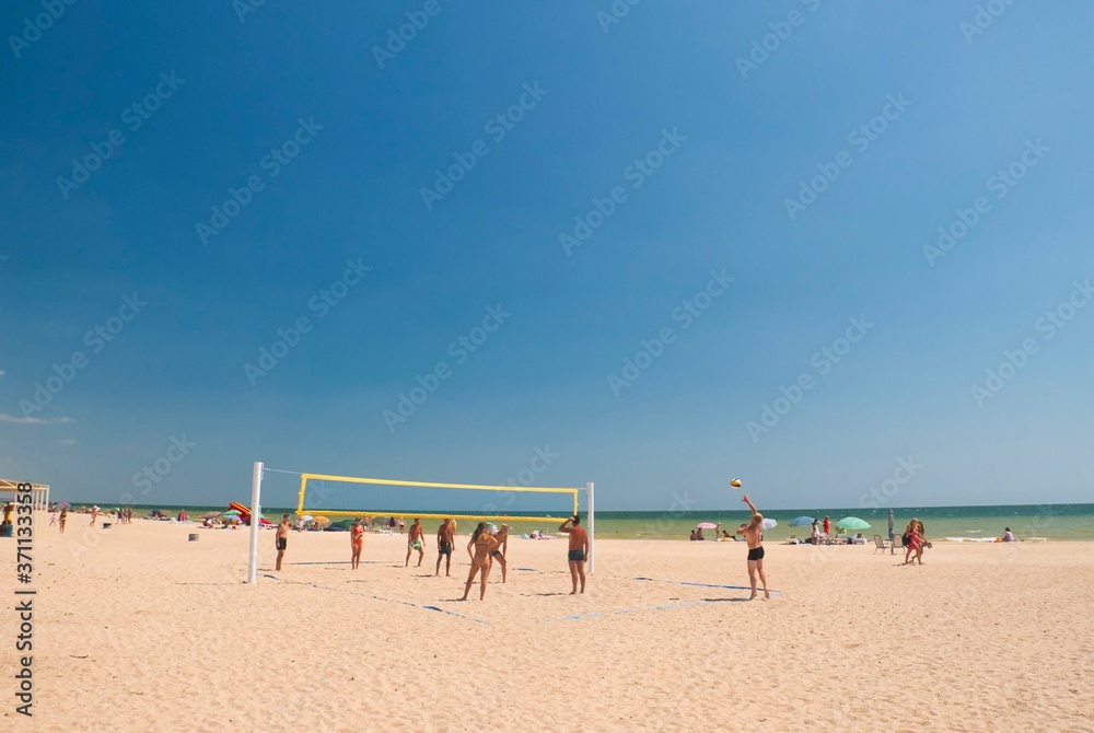 people on the seashore playing beach volleyball people on the seashore playing beach volleyball