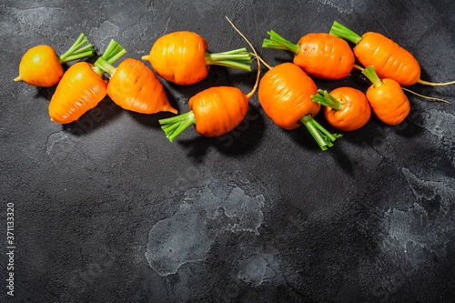 Short Rondo carrots on dark textured background with copy space,  top view